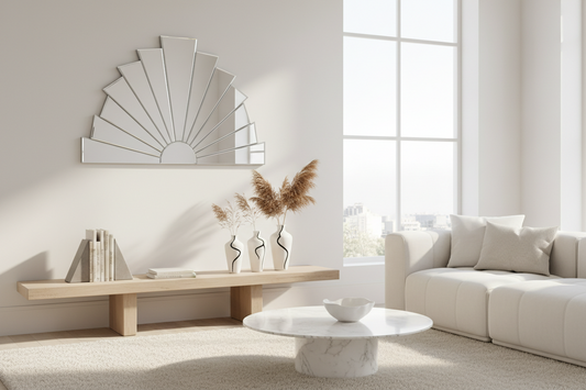 A beautifully styled minimalist living room featuring a deco wall mirror, minimalist bookends, and abstract line vases, by Fit-Flow.